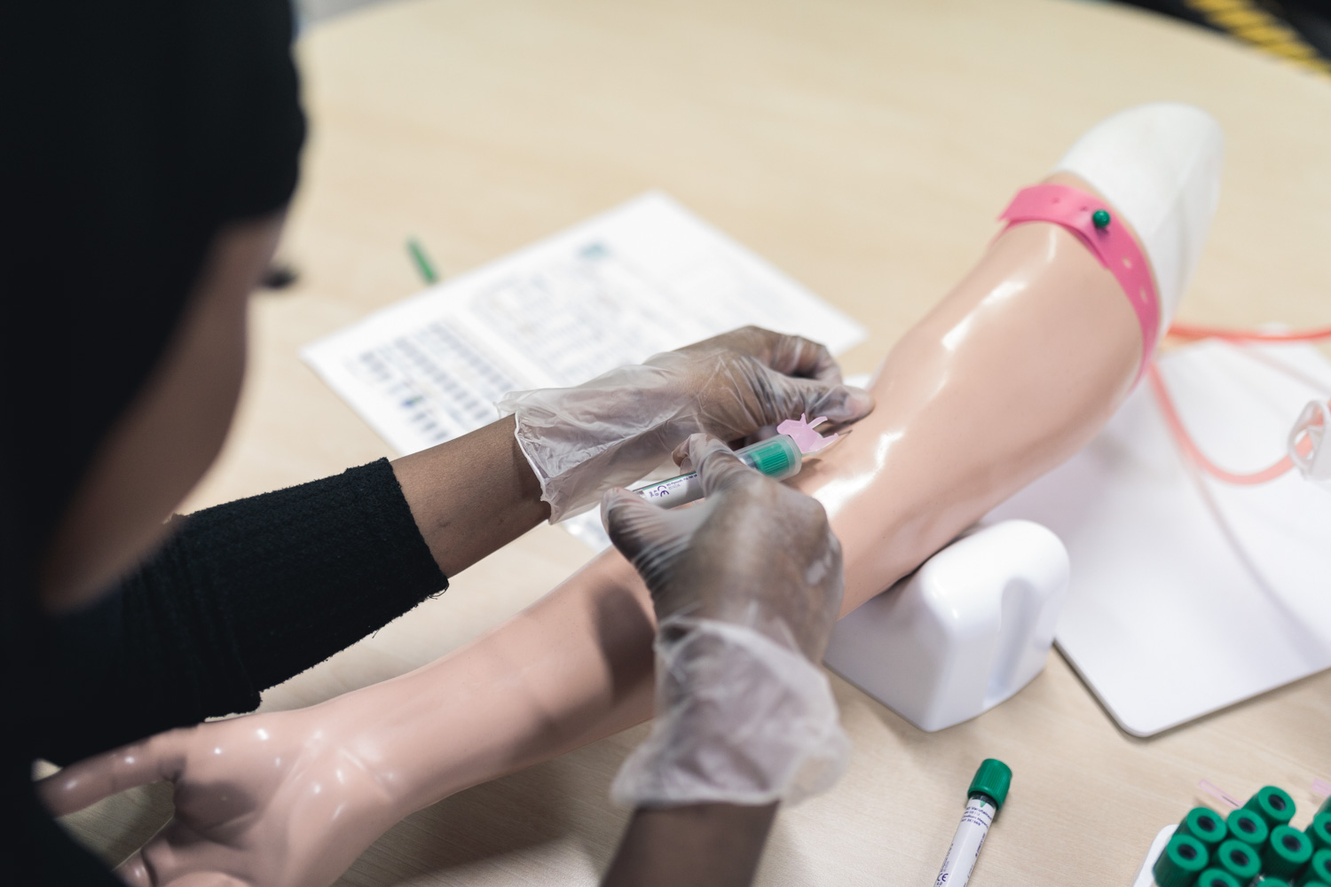 Elev som övar på att ta blodprov i armvecket på vård och omsorgsprogrammet
